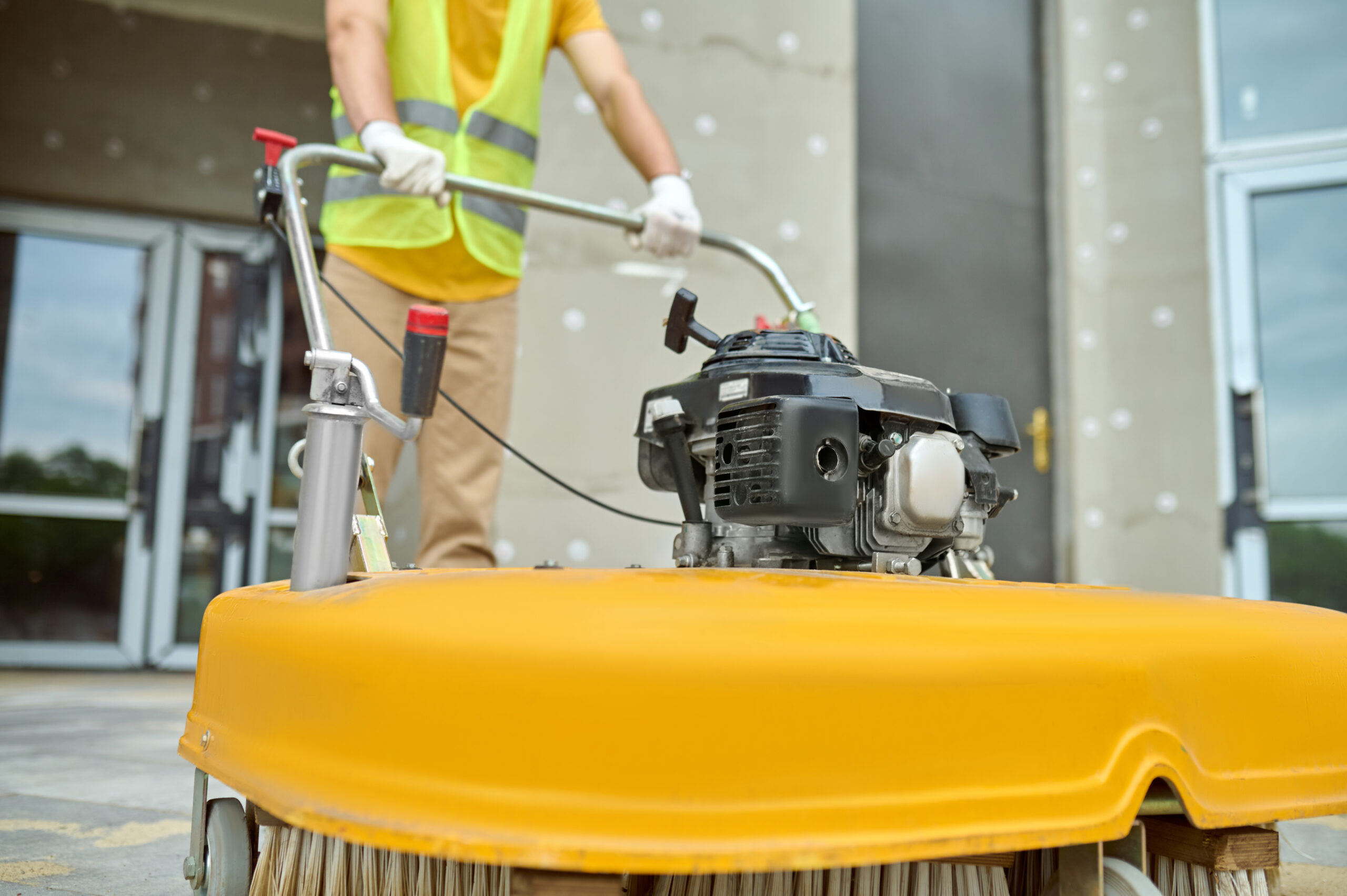 workman applying road sweeper construction site scaled